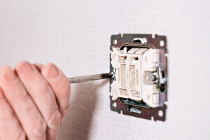 électricien installe l'interrupteur électrique au mur
