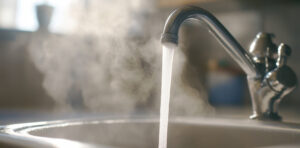 le robinet d'eau est ouvert et coule de l'eau brulante vapeur chaude