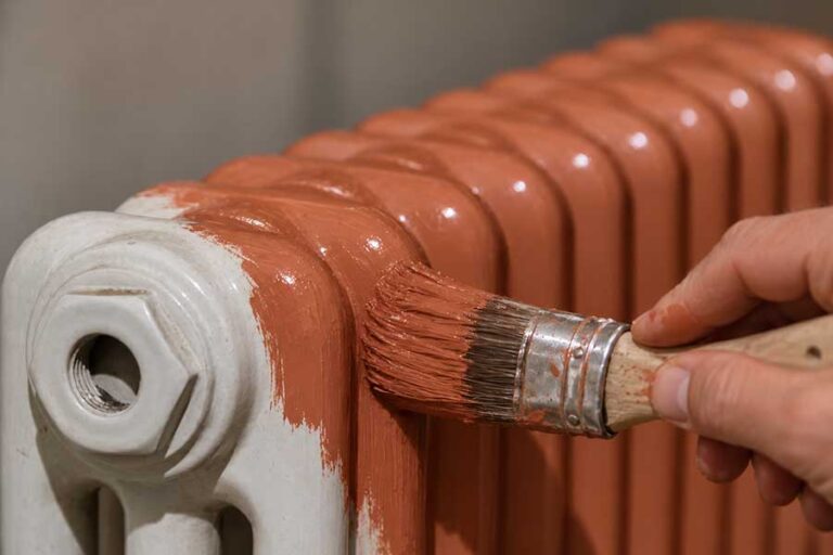 gros plan sur le pinceau qui repeint le radiateur eau chaude